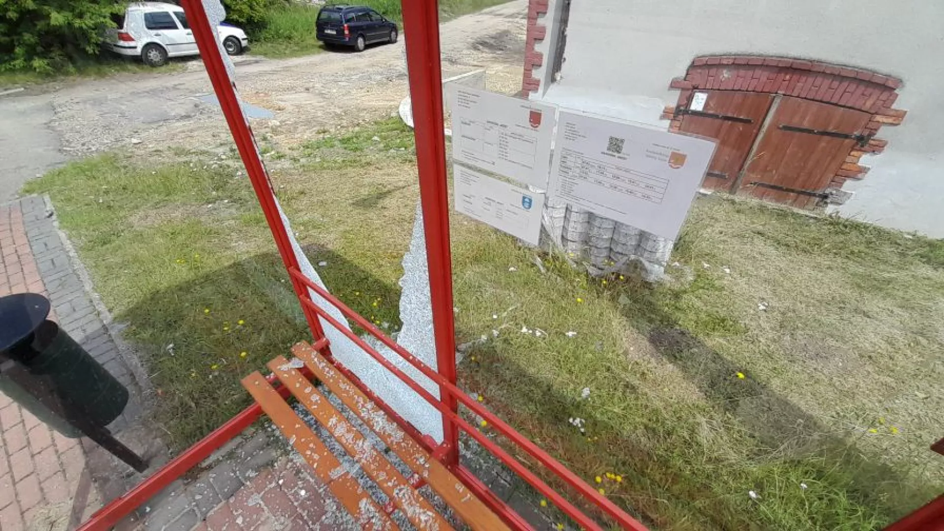 Na zdjęciu wiata przystankowa w Dankowie z potrzaskaną szybą, wokół okruchy szkła