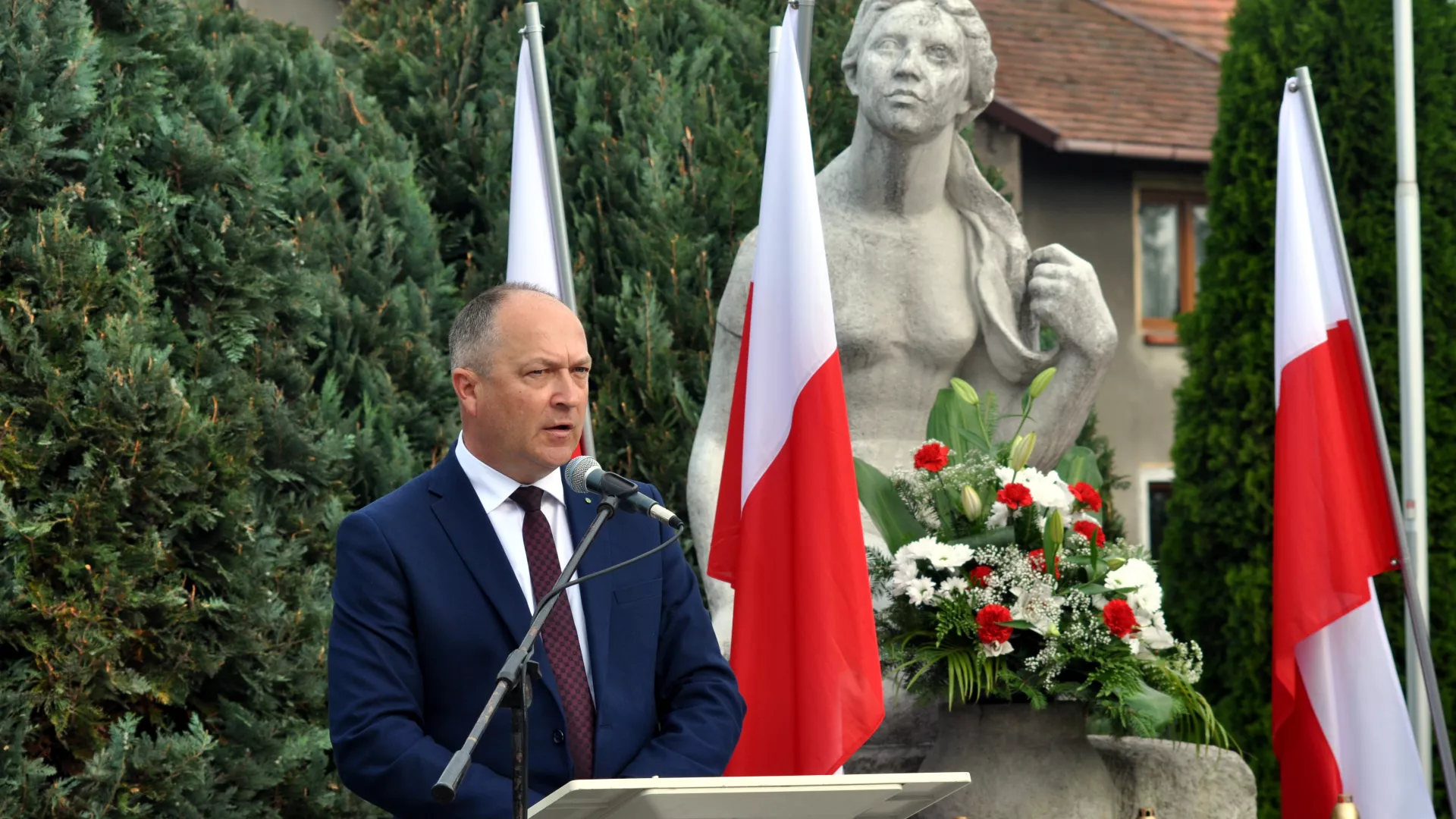 Wiceminister edukacji Henryk Kiepura przemawia pod pomnikiem ofiar wojny w Parzymiechach.