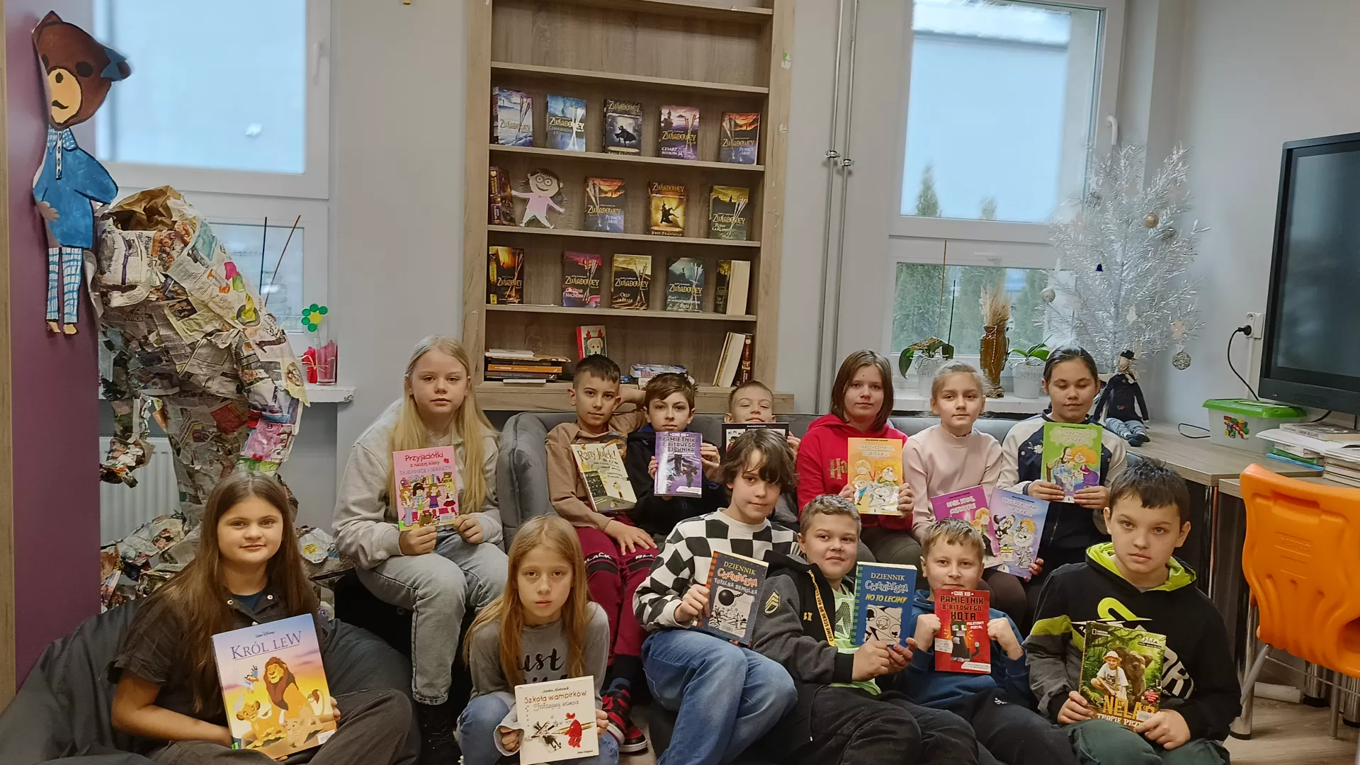 Klasa 4 podczas zajęć bibliotecznych, siedząca na kanapie nowo zakupionej w ramach NPRCZ.