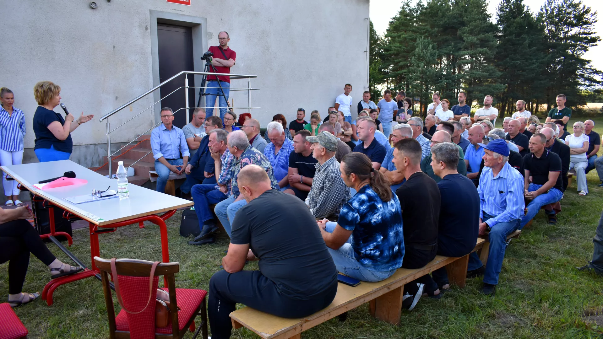 Wójt gminy zwraca się do mieszkańców Grabarzy podczas zebrania wiejskiego.