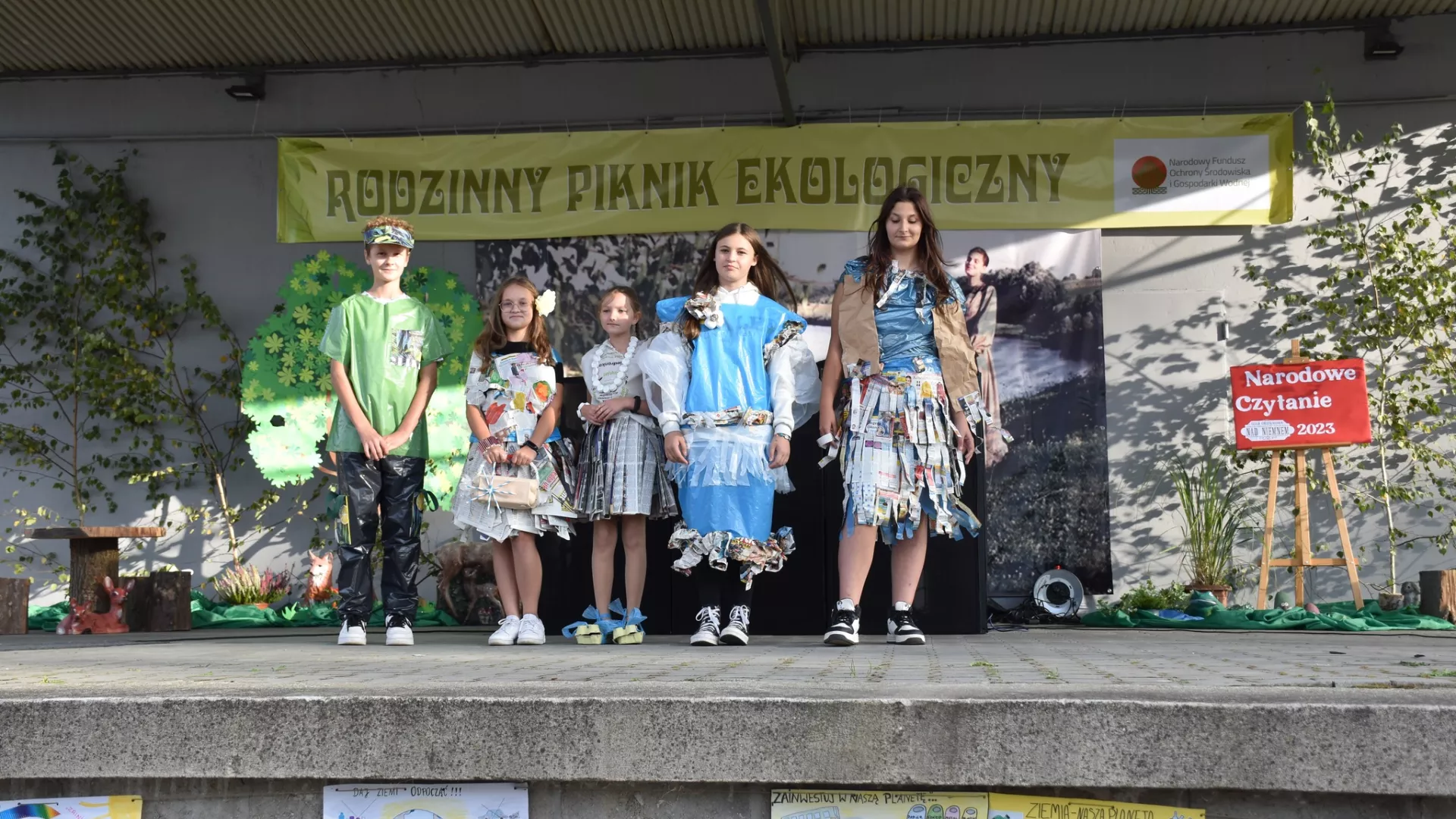 Na scenie dzieci w strojach z surowców wtórnych w pokazie eko mody.