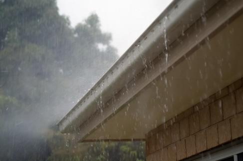 Opady deszczu, woda ściekająca swobodnie z obrzeża dachu domu