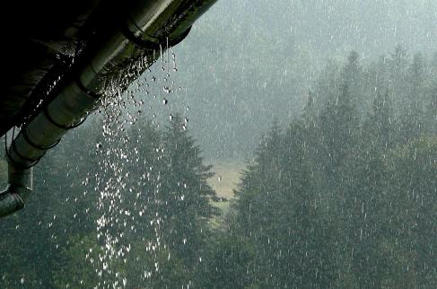 Na zdjęciu opady deszczu i woda wyciekająca z rynny.