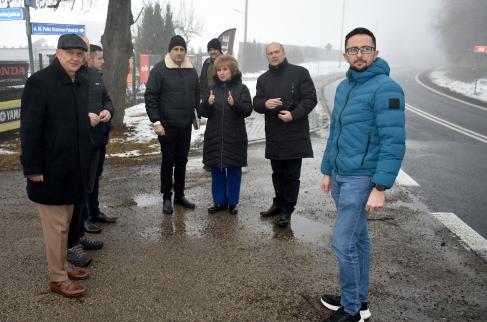   Uczestnicy spotkania omawiają w terenie kwestie związane z budową chodnika.
