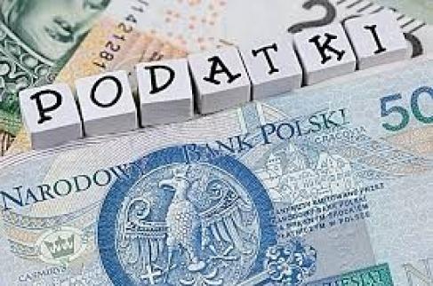 „Polskie banknoty i klocki z napisem „PODATKI”.”
